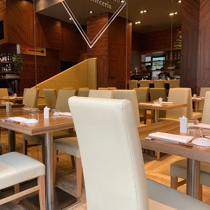 Tavoli e sedie bianche nella sala di Basara Milano